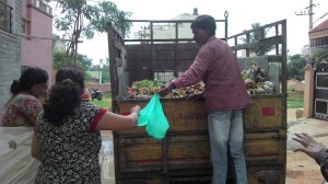 Ramana returns the plastic cover to a resident after dumping the wet waste 